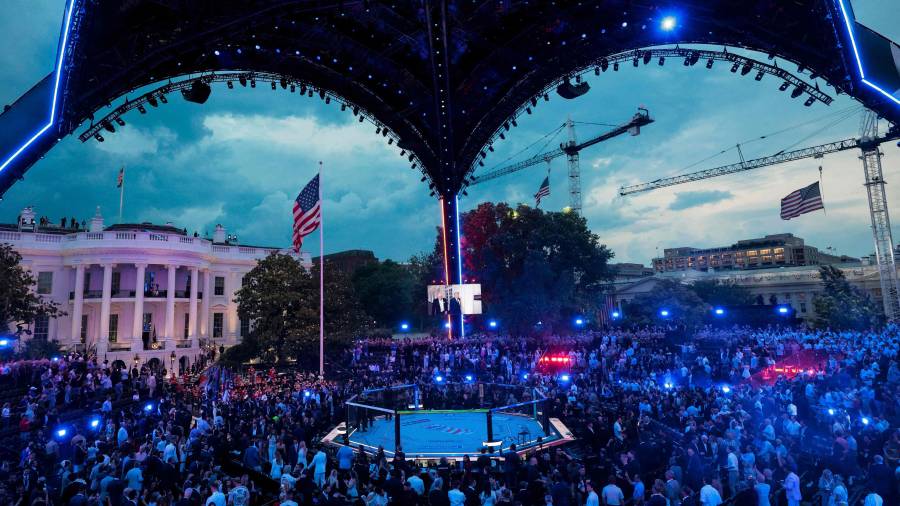 A screen shows US President Donald Trump walking with UFC CEO Dana White during the UFC Freedom 250 mixed martial arts event on the South Lawn of the White House in Washington, DC, June 14, 2026. (Photo by Evan Vucci / POOL / AFP)
