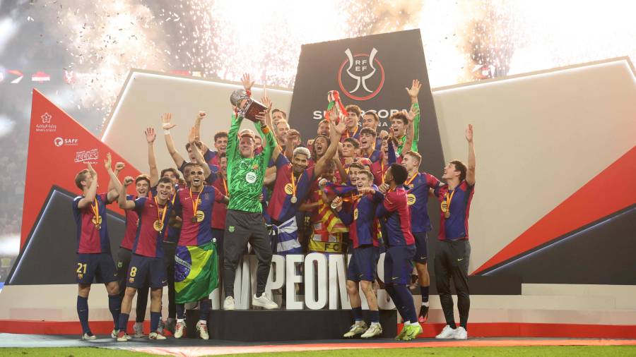 Barcelona’s players celebrate with the trophy after winning the Spanish Super Cup final football match between Real Madrid and Barcelona at the King Abdullah Sport City in Jeddah on January 12, 2025. (Photo by Haitham AL-SHUKAIRI / AFP)