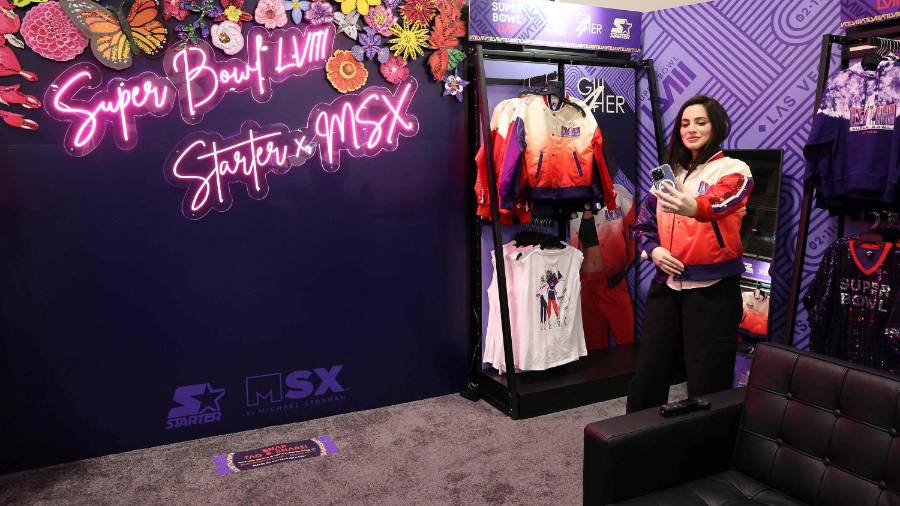 $!LAS VEGAS, NEVADA - FEBRUARY 06: A woman takes a selfie as she tries on merchandise in the NFL Super Bowl Experience ahead of Super Bowl LVIII on February 06, 2024 in Las Vegas, Nevada. Jamie Squire/Getty Images/AFP (Photo by JAMIE SQUIRE / GETTY IMAGES NORTH AMERICA / Getty Images via AFP)