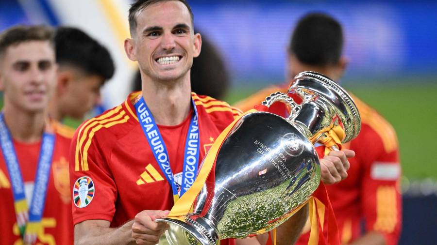 $![Spain's midfielder #08 Fabian Ruiz celebrates with the trophy after winning the UEFA Euro 2024]